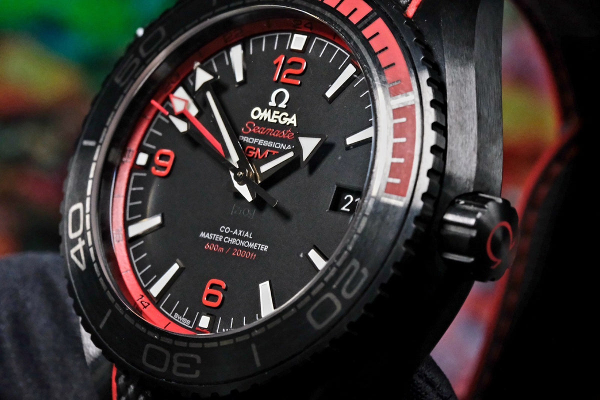 OMEGA Seamaster Planet Ocean 600M Deep Black GMT 215.92.46.22.01.003 — dial at an angle with red GMT scale